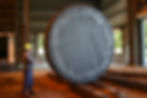 Worker measuring a massive steel disc, inside a Scot Forge industrial facility.