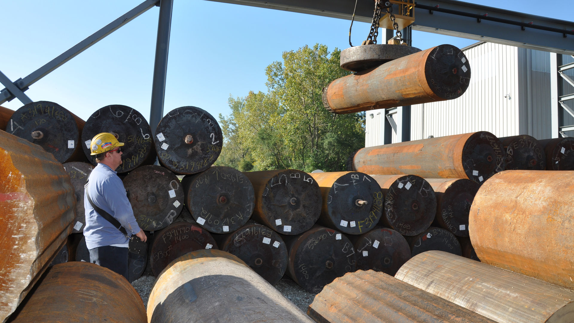 Worker moving raw material in an ingot yard at Scot Forge