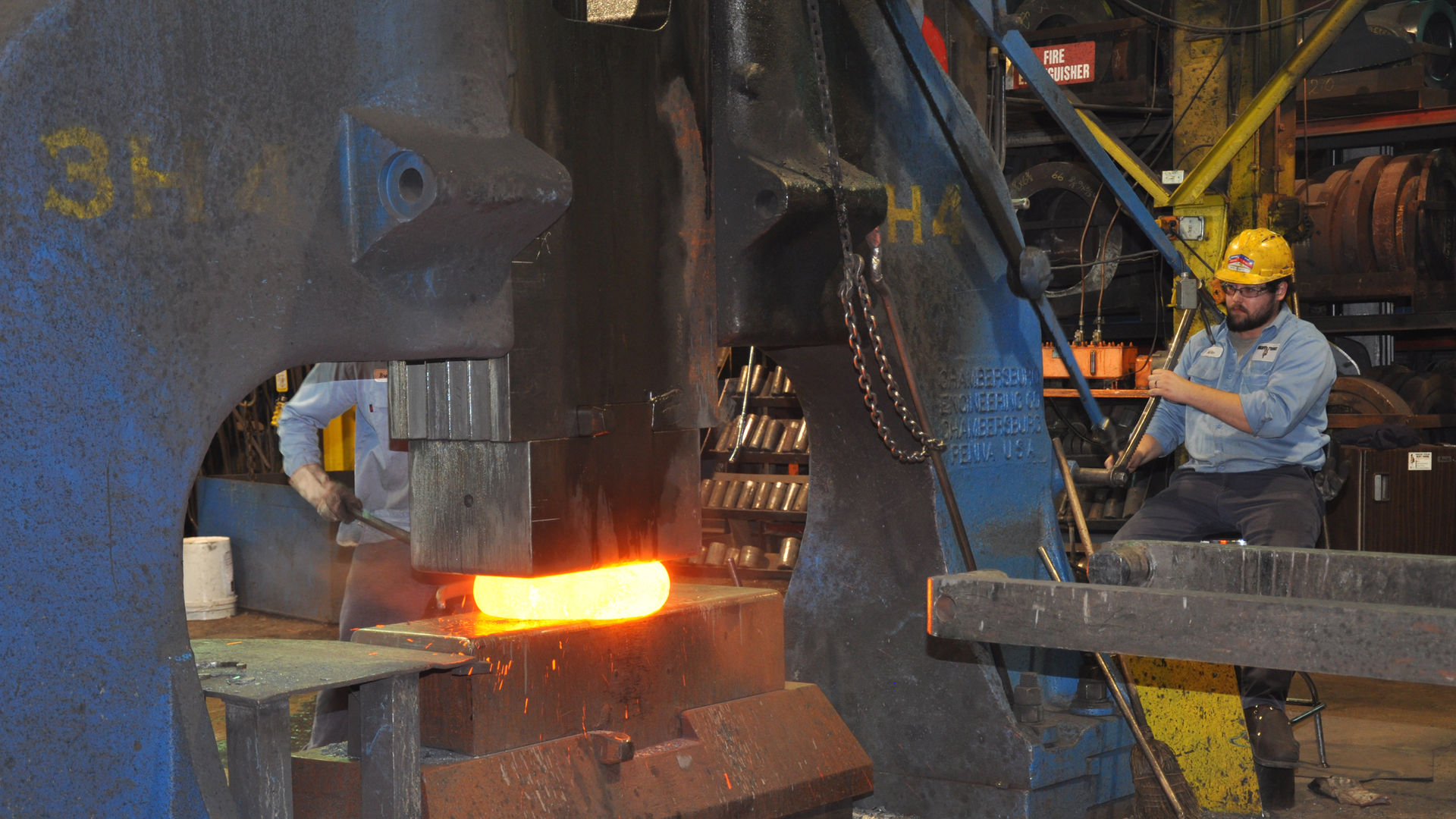 worker flattening the hot piece of metal on a hammer in step two of the disc forging process
