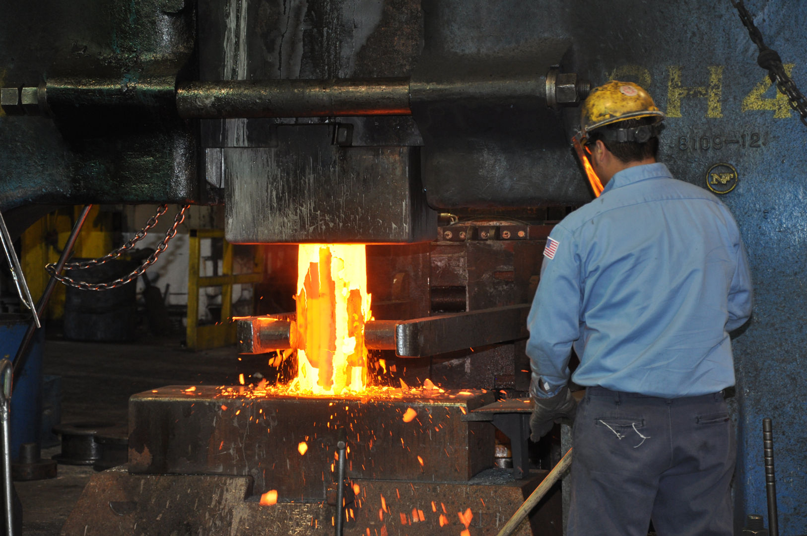 Worker upsetting a hot piece of metal in step one of the disc forging process