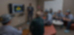 Man giving presentation to group of people in a meeting about a forge simulation.